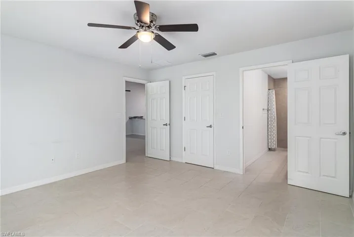 Bathroom with tile patterned flooring, double vanity, and tiled shower