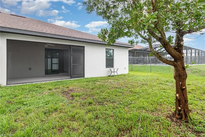 Back of house featuring a fenced backyard, stucco siding, roof with shingles, and a gate