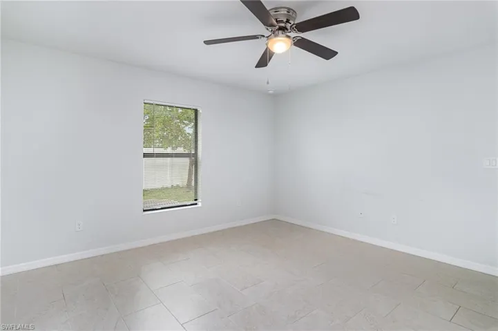 Unfurnished bedroom with connected bathroom and a ceiling fan