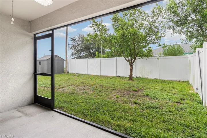 View of yard with a ceiling fan and a lanai