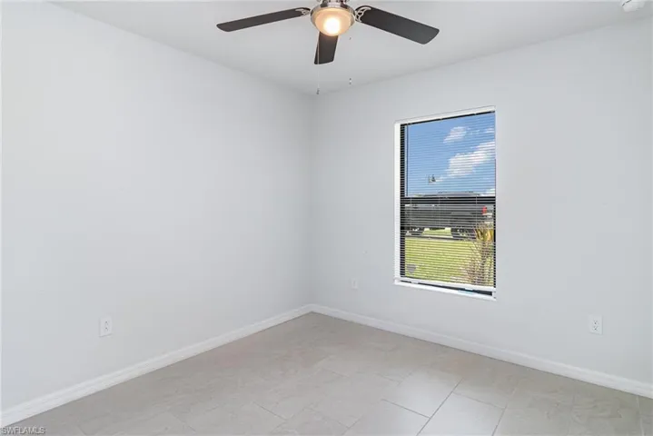 Empty room with baseboards and ceiling fan