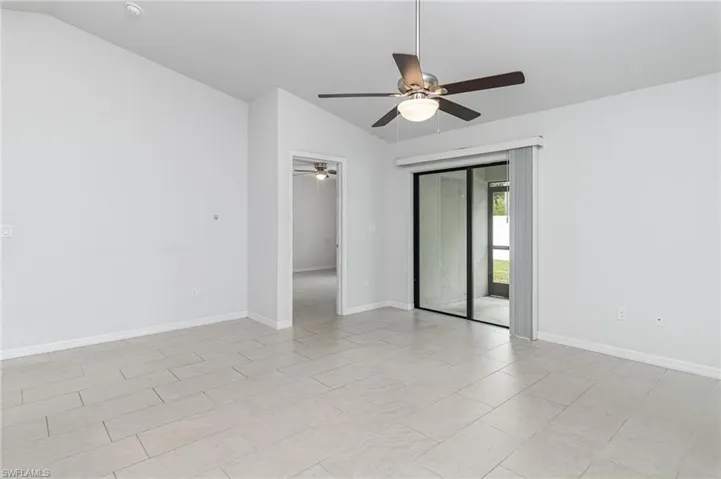 Kitchen with gray cabinetry, stainless steel dishwasher, light tile patterned flooring, open floor plan, and lofted ceiling