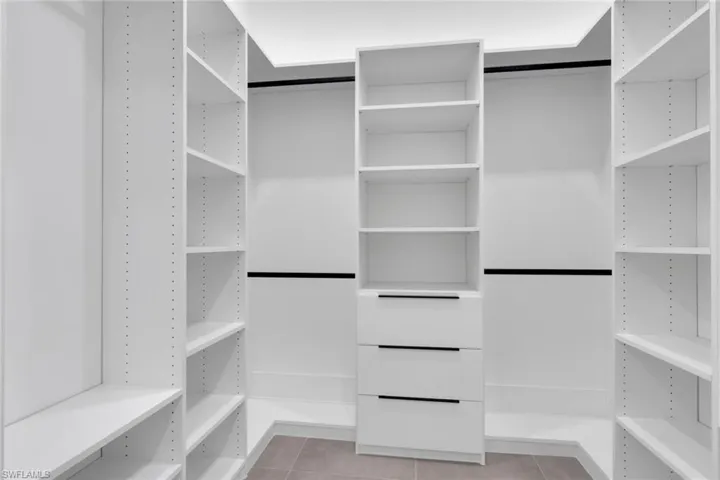 White custom closet system featuring adjustable shelving and hanging rods
