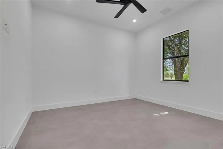 Interior room with clean white walls and light gray tile flooring
