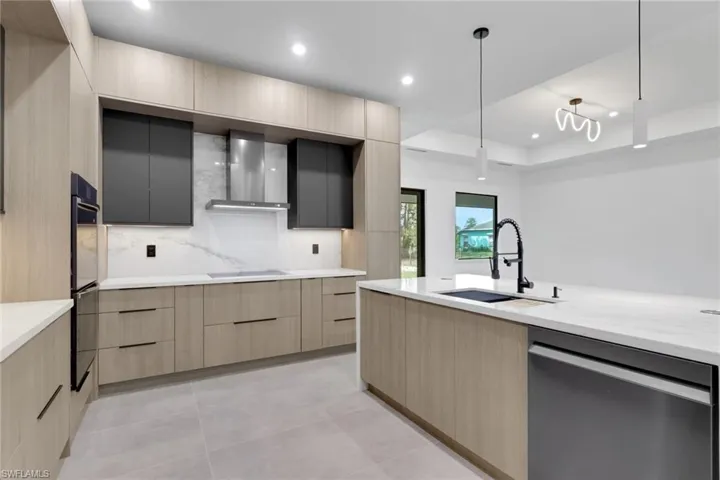 Gourmet kitchen with light wood-finish cabinetry, dark contrasting upper cabinets, and a large central island