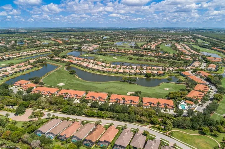 View of property location featuring nearby suburban area, a golf course, and a large body of water