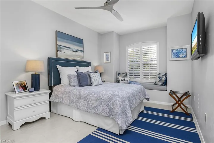 Tiled guest bedroom with baseboards and ceiling fan