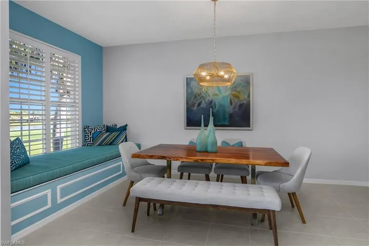 Dining area with light tile patterned flooring and a chandelier. Could also be a family room