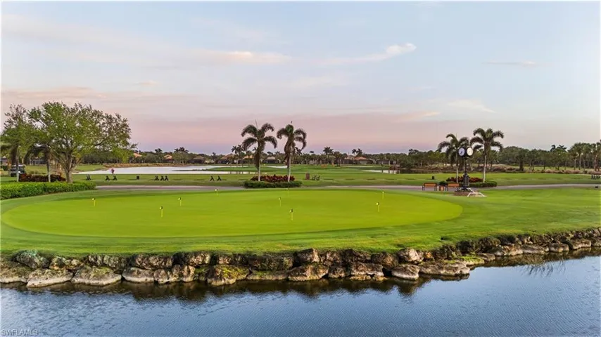 View of home's community with view of golf course, a water view, and a yard