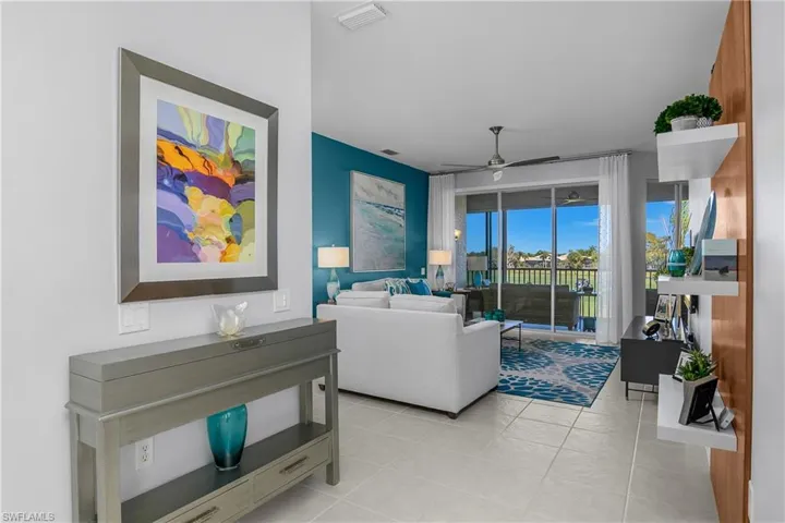 Living room featuring a ceiling fan and light tile patterned floors