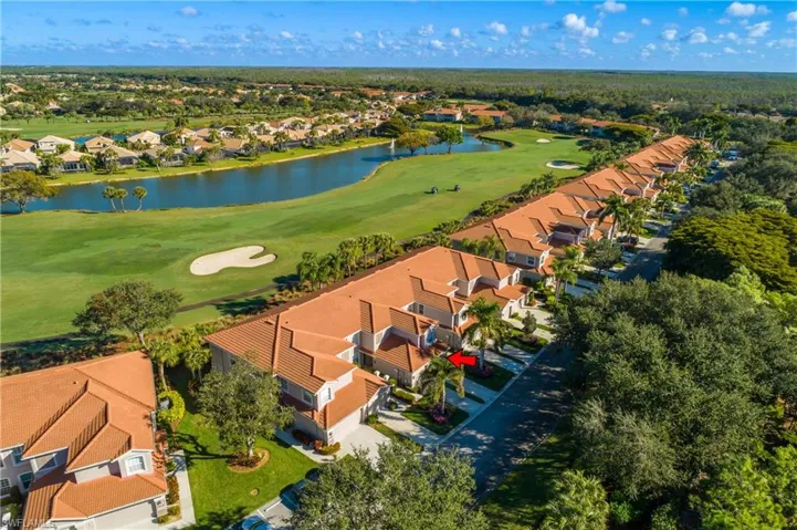 Aerial view of residential area featuring a nearby body of water and a golf club