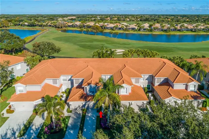 Aerial perspective of suburban area with a golf course and a large body of water