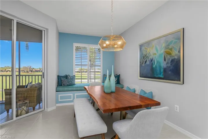 Dining room featuring light tile patterned floors and a chandelier.  Could also be a family room