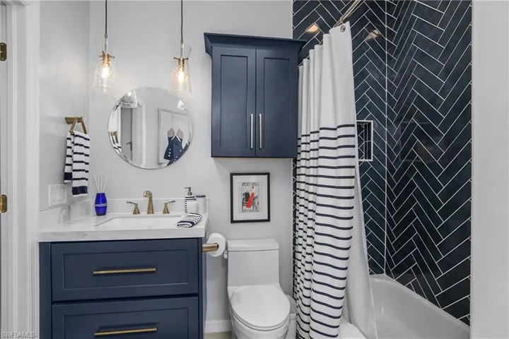 Full guest bath featuring shower / bath combination with curtain and vanity