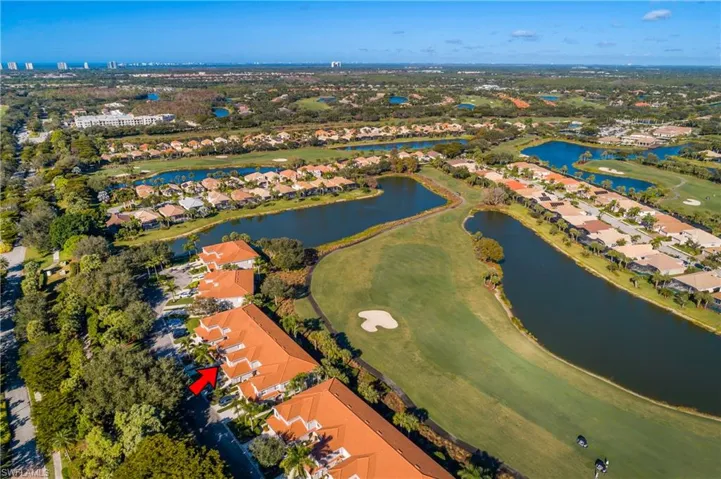 Aerial perspective of suburban area featuring a golf course and a large body of water