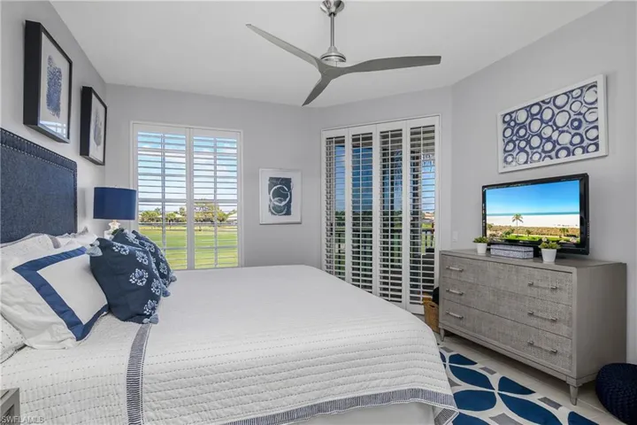 Primary Bedroom featuring multiple windows, access to exterior, and ceiling fan
