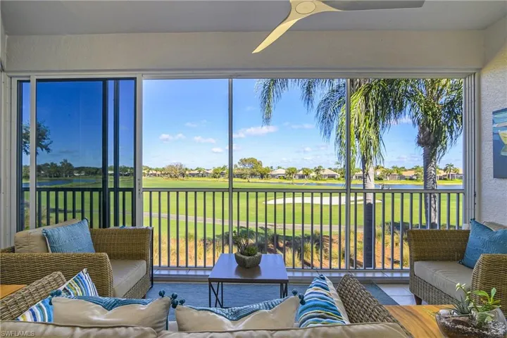 Sunroom / solarium with a water view, view of golf course, and a residential view