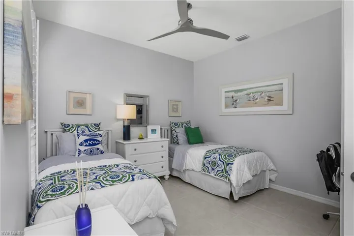 Guest bedroom with a ceiling fan and light tile patterned floors