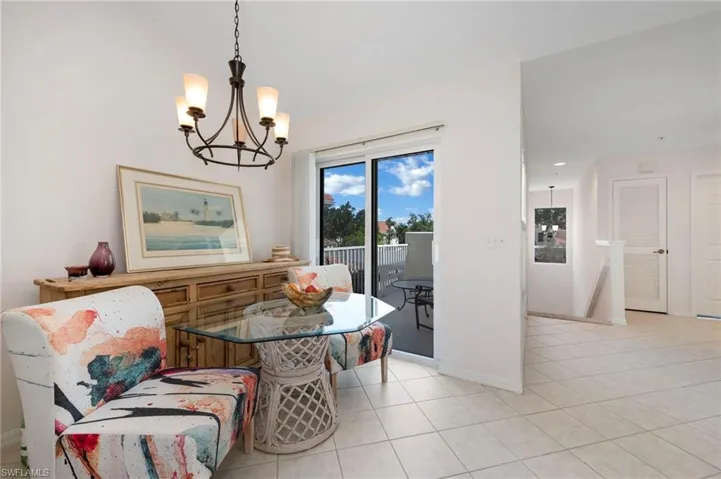Tiled dining space with a chandelier and vaulted ceiling