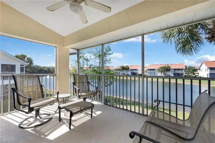Sunroom featuring plenty of natural light, ceiling fan, vaulted ceiling, and a water view