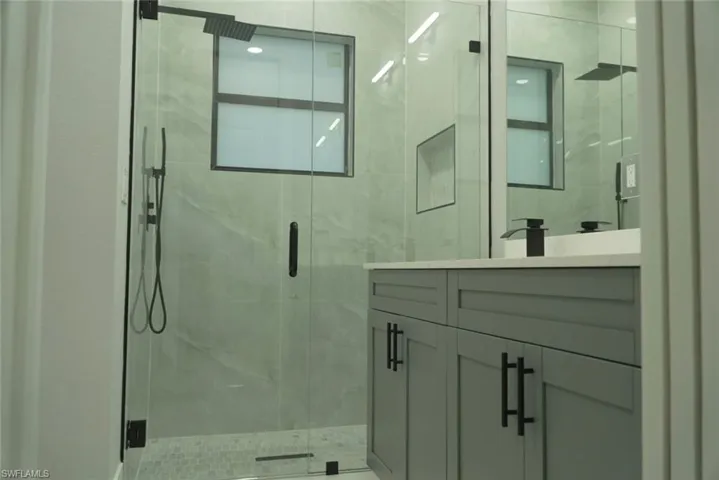 Full bath with vanity and a marble finish shower