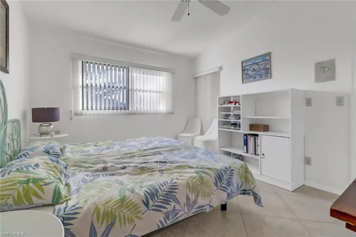 Bedroom featuring lofted ceiling, light tile patterned floors, and ceiling fan