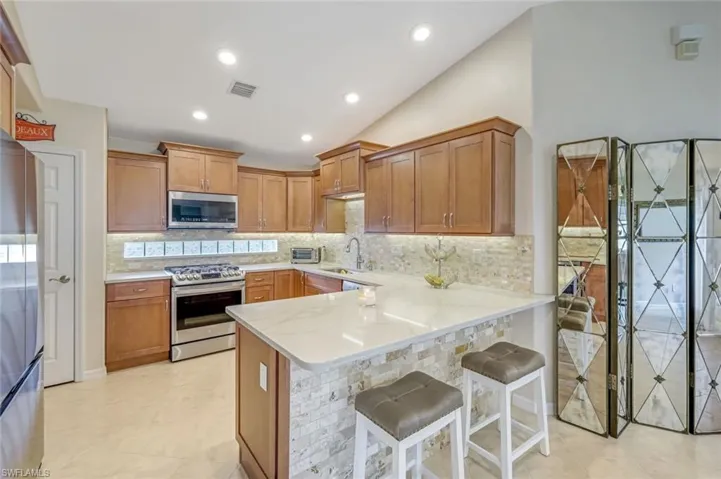 Full View of Updated Kitchen.  Decorative Tile on Backsplash and Breakfast Bar.