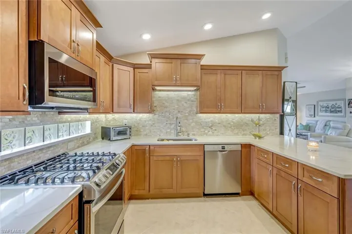 Kitchen featuring stainless steel appliances, backsplash, gas stove and beautiful counters