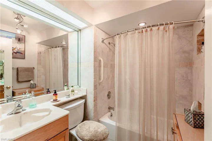 Full bathroom with shower / bath combo, toilet, and vanity
