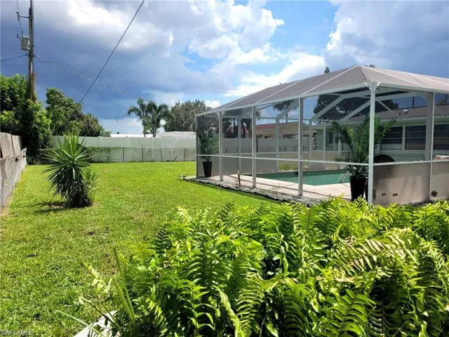 View of yard featuring glass enclosure and a fenced in pool