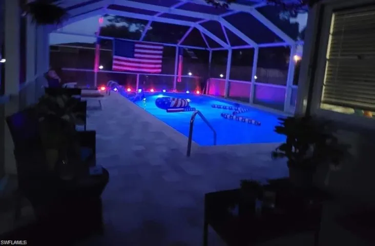 View of pool with a patio area and a lanai