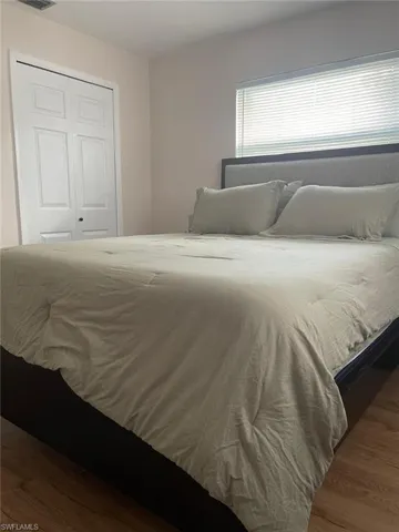 Bedroom featuring dark wood-style flooring and a closet