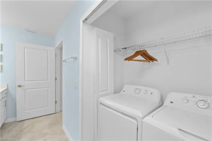 Clothes washing area with light tile patterned floors, baseboards, visible vents, laundry area, and washer and dryer