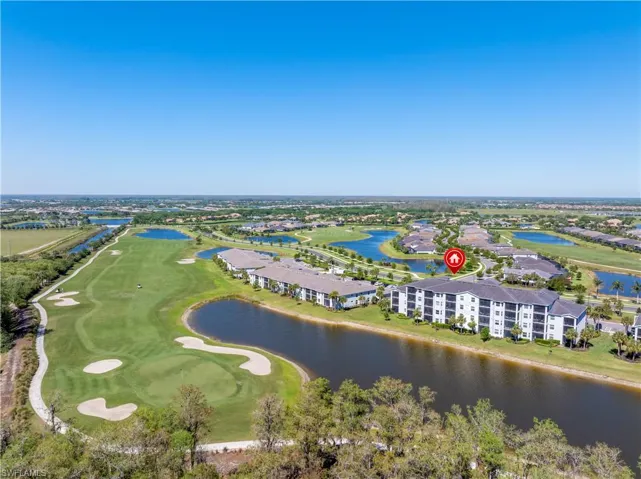 Birds eye view of property with view of golf course and a water view