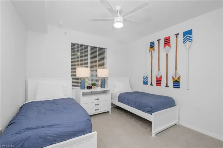 Bedroom with light colored carpet, baseboards, and ceiling fan