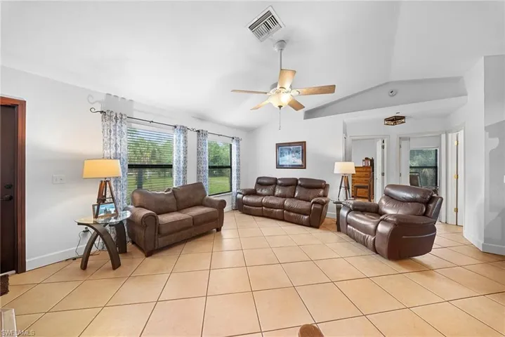 Spacious interior featuring tile flooring, vaulted ceilings, and a ceiling fan