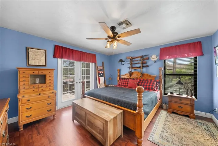 Spacious room featuring wood-finish flooring, a ceiling fan with integrated lighting, and light blue walls