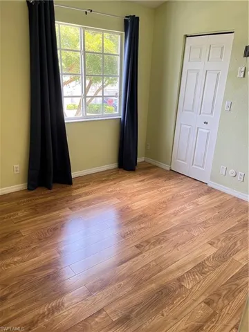 Master bedroom with wood style finished floors and baseboards
