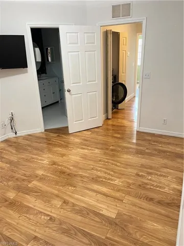 Master bedroom with light wood style flooring and baseboards