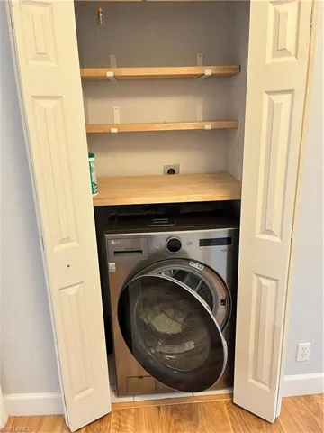 Laundry room featuring washer / clothes dryer combo and shelving