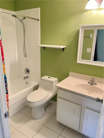 Full bath featuring vanity, shower / tub combo, and tile patterned floors