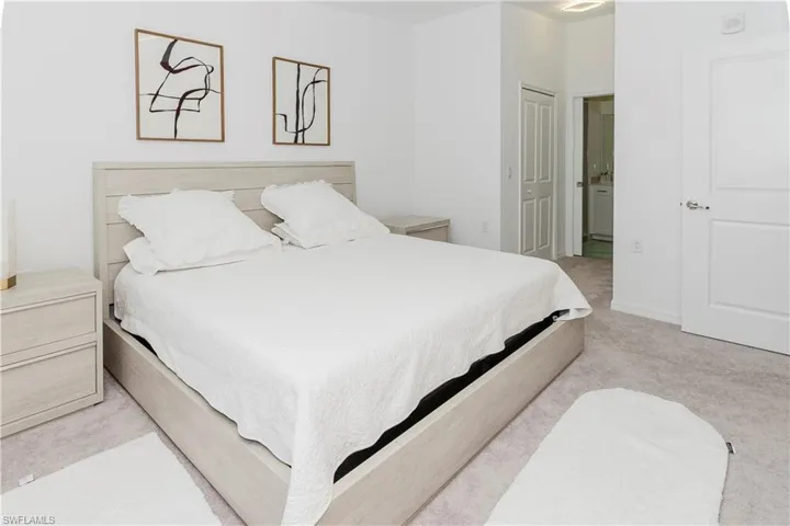 Bedroom with light carpet and connected bathroom