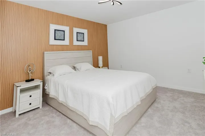 Bedroom with carpet floors and wooden walls