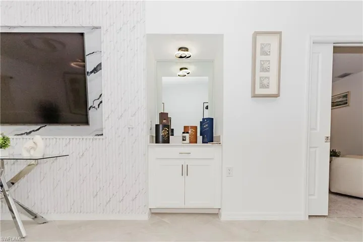 Corridor featuring light tile patterned floors and wallpapered walls