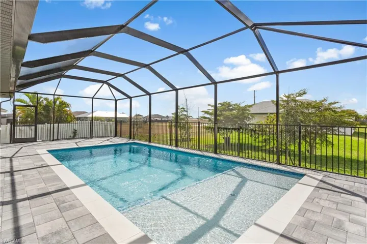 Step outside to SCREENED LANAI w/ SALTWATER POOL, landscaped surrounding & FULLY EQUIPED OUTDOOR KITCHEN w/ BUILT-IN stainless steel BBQ GRILL, SINK, BEVERAGE REFRIGERATOR, GRANITE COUNTERTOPS & MODERN BACKSPLASH, ideal for OUTDOOR DINING & ENTERTAINING!