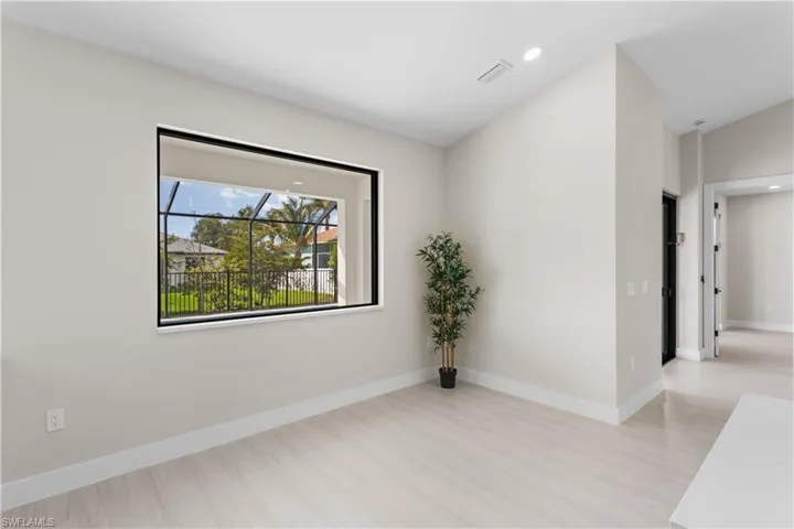 LARGE PICTURE WINDOW brings in natural light & offers views of screened lanai & backyard.
