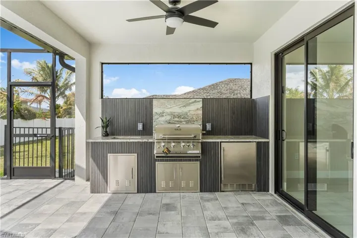 Outdoor kitchen with beverage refrigerator, 4-burner GRILL, extra storage space, and backsplash!