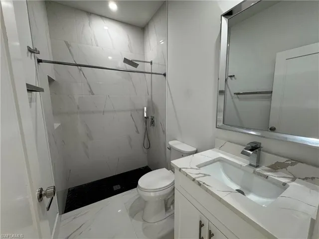Bathroom featuring a vanity with a stone-finish countertop, undermount sink, and chrome faucet