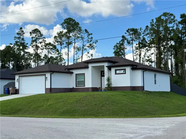 Single-story residence featuring a smooth stucco exterior with contrasting foundation trim, a multi-hip asphalt shingle roof, a two-car garage, and a recessed entryway