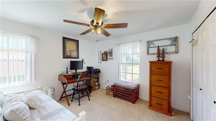 Office with light carpet and ceiling fan